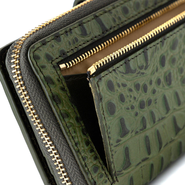 Back view of women’s green croc-embossed leather travel wallet with dual zip compartments and gold hardware