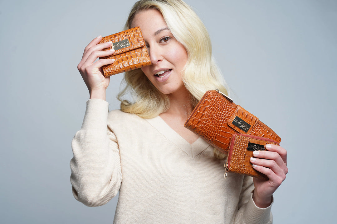 Hedonist Chicago best-selling leather wallets and ratchet belts in full-grain vegetable-tanned leather, displayed on a natural surface showing patina development from daily carry