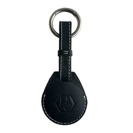 A black leather AirTag Holder with white contrast stitching, featuring an embossed logo on the teardrop-shaped tag and a silver metal key ring