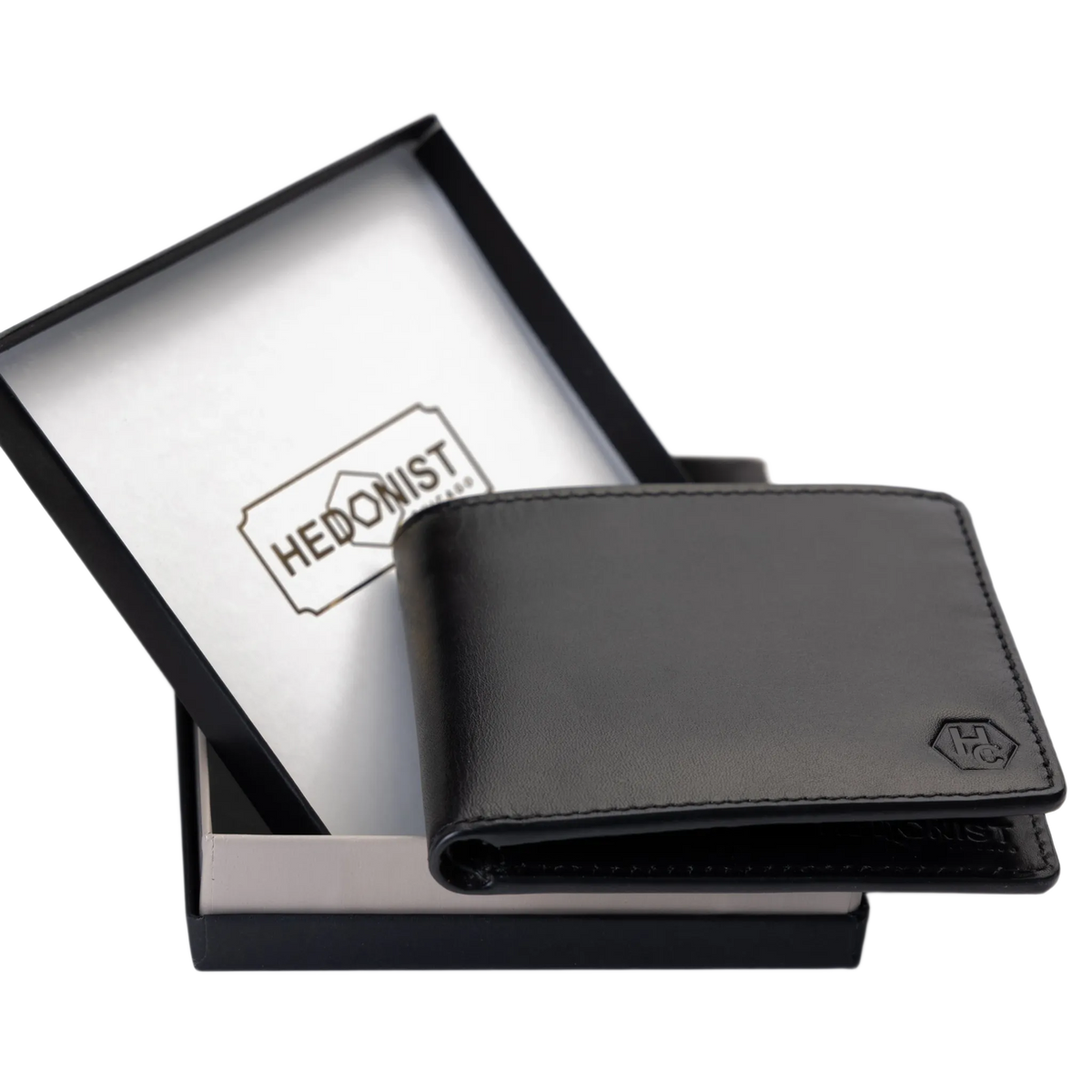 A black leather bi-fold wallet with an embossed logo, displayed next to its black presentation box with a white interior card printed with the brand name 'HEDONIST'.