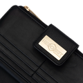 Close-up of a black leather wallet with a gold-tone metal brand plaque reading 'HEDONIST CHICAGO'.