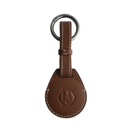 A brown leather AirTag Holder with a teardrop-shaped tag, white contrast stitching, an embossed logo, and a silver metal key ring