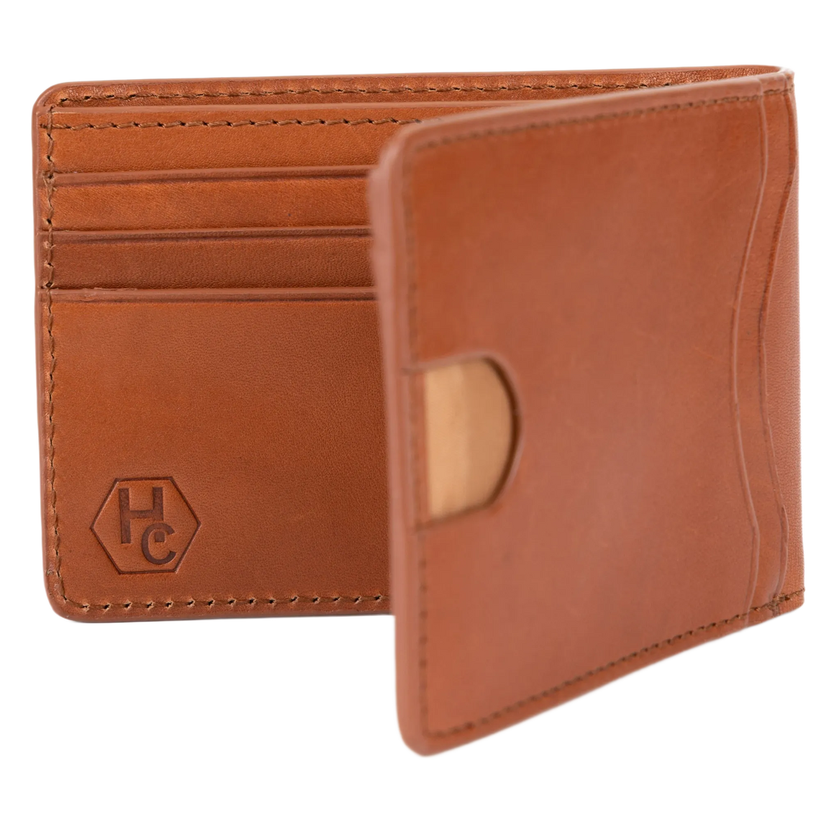 A tan leather bifold wallet shown open, displaying its interior card slots and a debossed 'HC' logo on the left pocket. A small light tan circular accent is visible on the right pocket.