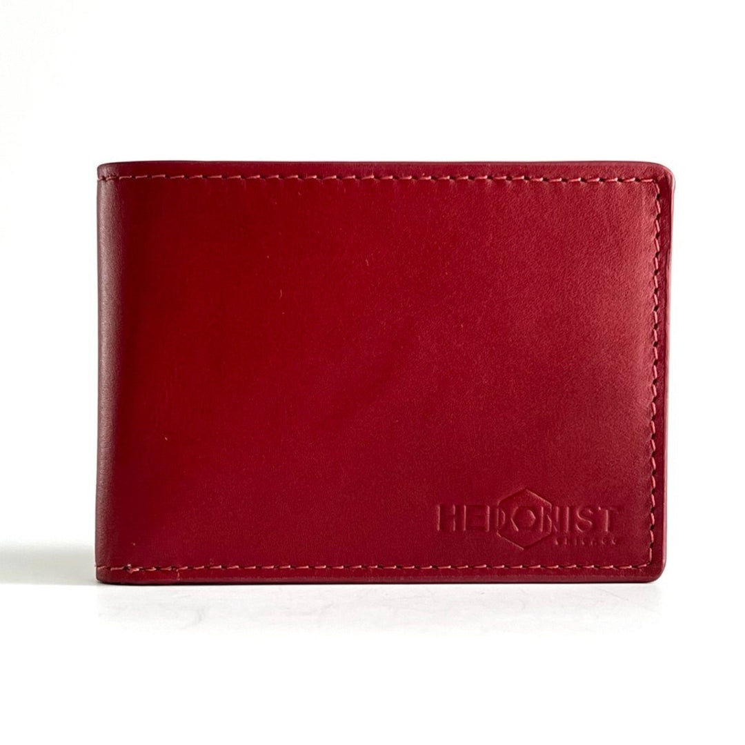 A red leather bifold wallet with visible stitching and an embossed logo reading 'HEDONIST CHICAGO' on the lower right, photographed on a clean white background.