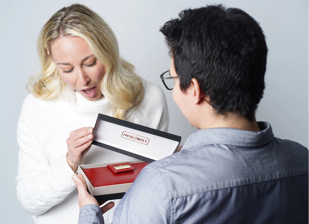 Two people looking at a product in a box with a visible brand logo.