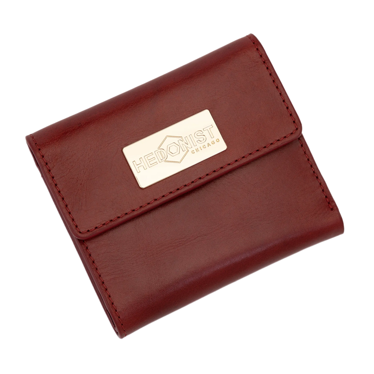 A red leather bi-fold wallet with a gold-tone metal brand plaque on the front flap.