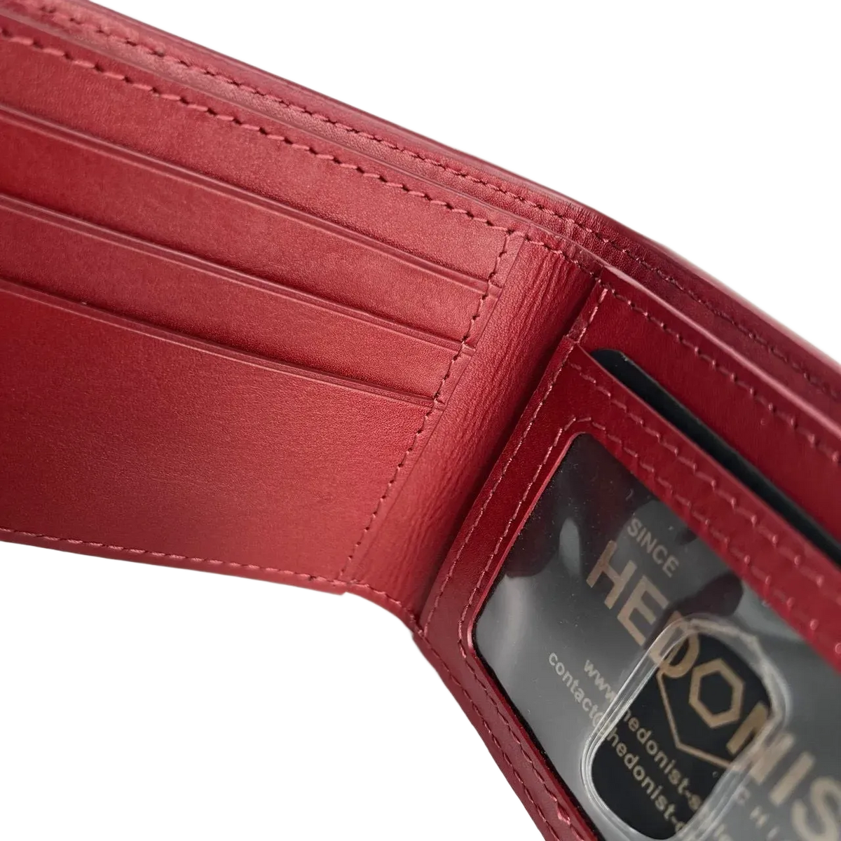 Close-up of the interior of a red leather wallet showing card slots, stitching, and a clear ID window with a visible Hedonist brand card.