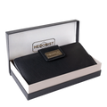 A black textured leather wallet presented in an open branded box. The wallet has a small gold-tone metal plaque on the front with the brand name 'HEDONIST CHICAGO'.