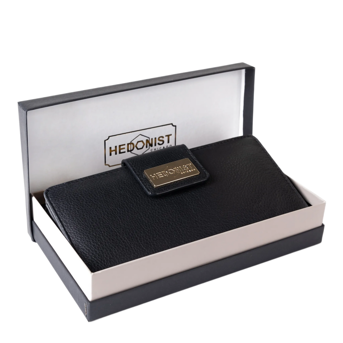 A black textured leather wallet presented in an open branded box. The wallet has a small gold-tone metal plaque on the front with the brand name 'HEDONIST CHICAGO'.