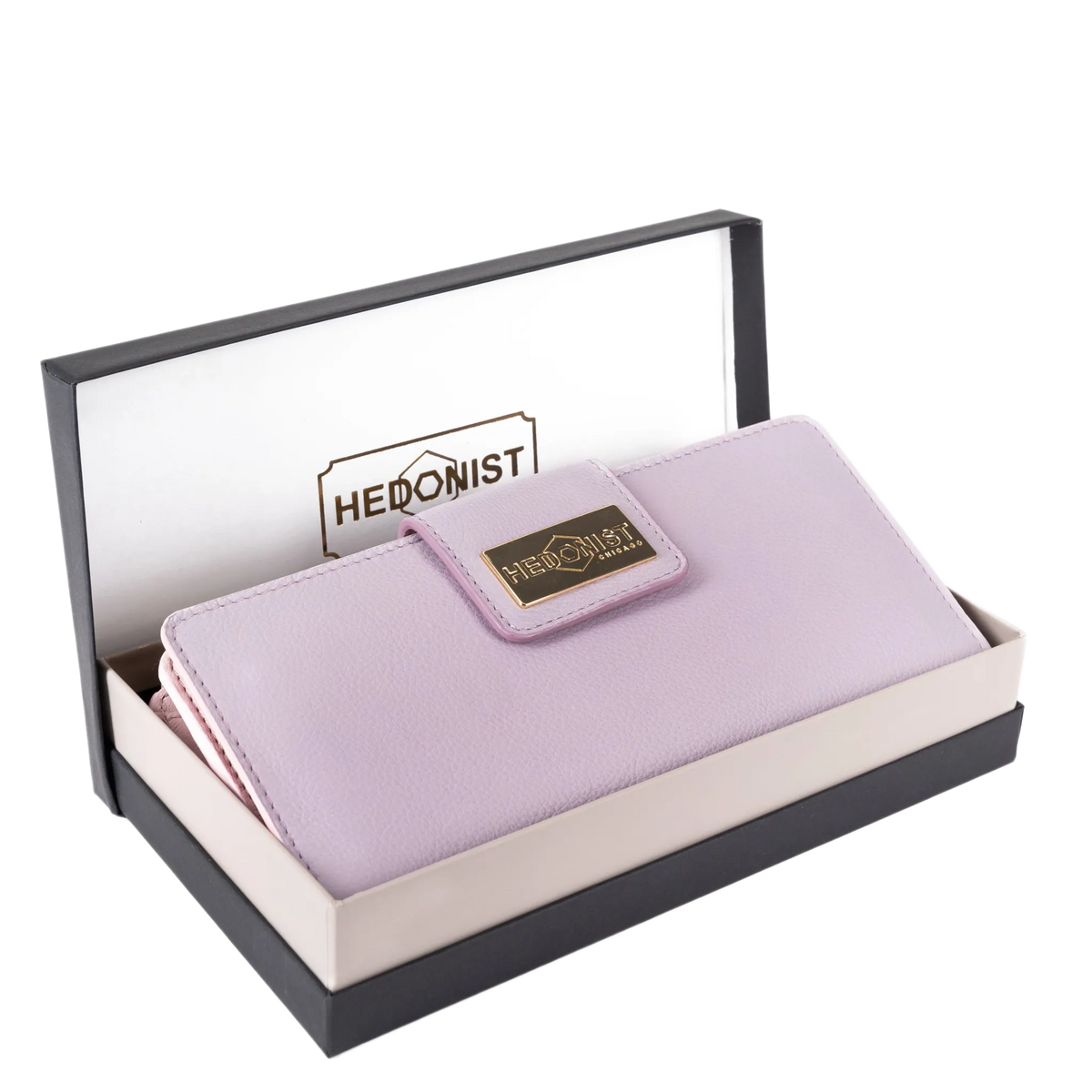 A light purple wallet presented in an open black and cream gift box. The wallet has a textured finish and a gold-tone metal brand plaque that reads 'HEDONIST'.