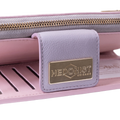 Close-up of a pink wallet or clutch with a lavender leather tab featuring a gold-tone metal brand plate that reads HEDONIST CHICAGO.