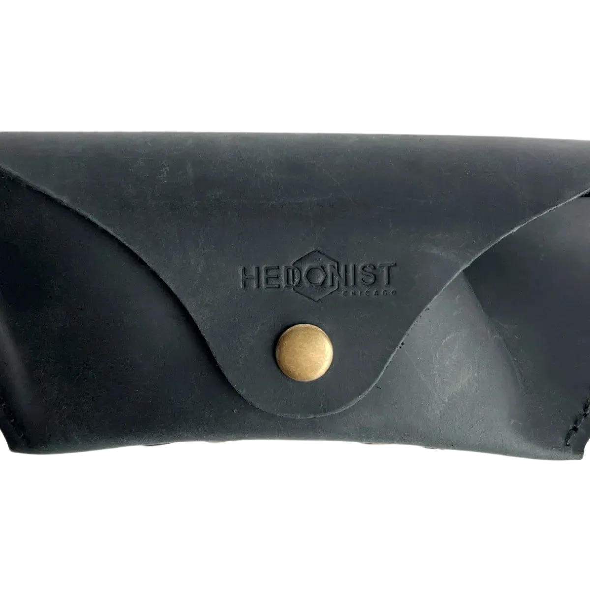 Soft Leather Eye Glasses Case in Black, closed, front view with embossed Hedonist logo and snap closure
