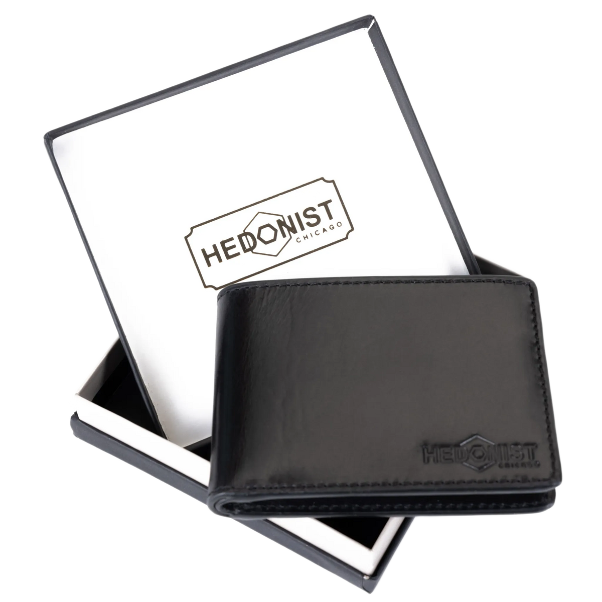 A black leather bi-fold wallet with an embossed HEDONIST logo, displayed in front of its open black and white presentation box.