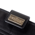 Snap-secured front flap detail on the black leather travel wallet