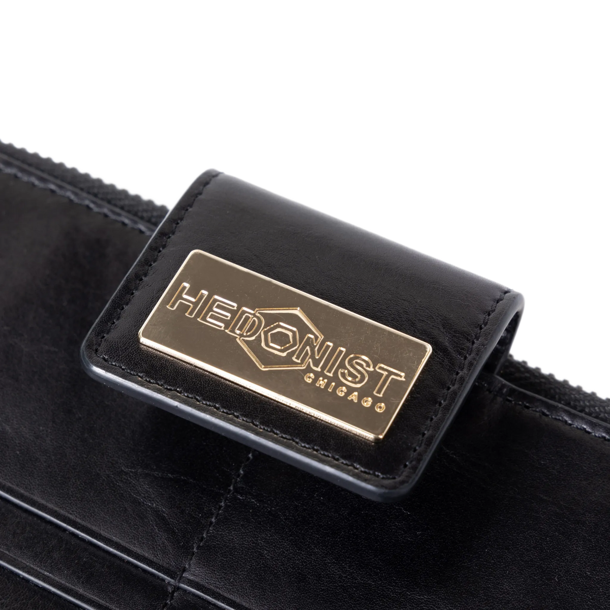 Snap-secured front flap detail on the black leather travel wallet