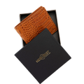 A brown crocodile-embossed leather wallet displayed inside an open black presentation box, with the brand box lid placed in front. 