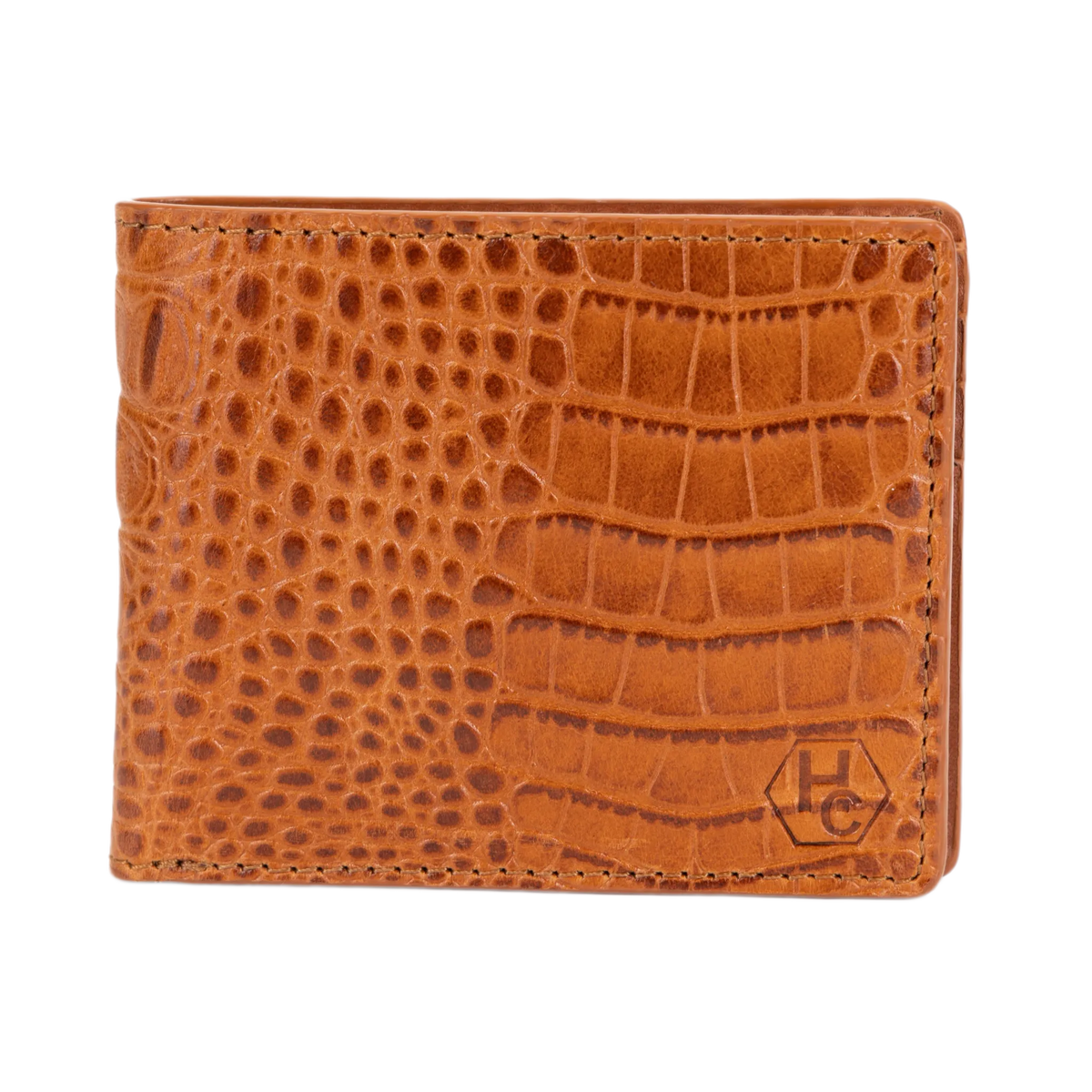 A brown bi-fold wallet with a crocodile-embossed texture, featuring a small embossed 'HC' logo in the bottom right corner, set against a plain white background.