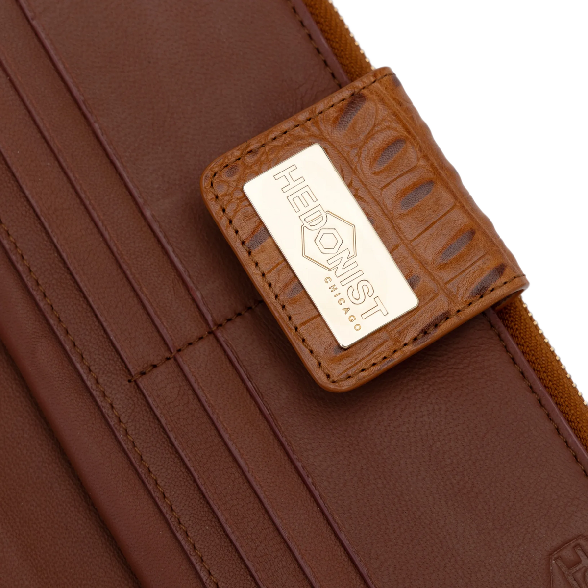 Snap-secured front flap detail on the brown croco-embossed leather travel wallet
