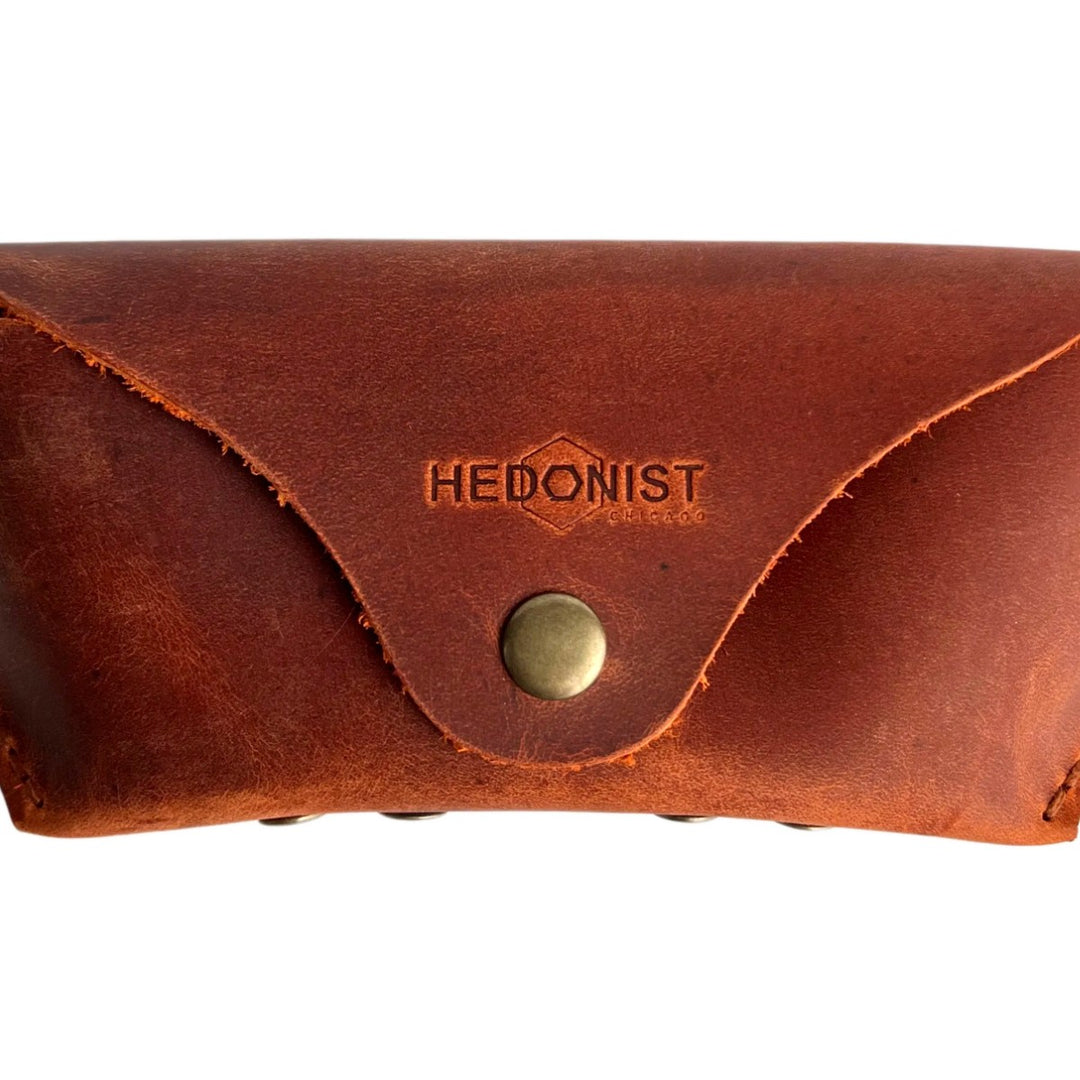 Soft Leather Eye Glasses Case in Cognac, closed, front view with embossed Hedonist logo and snap closure