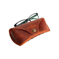 Soft Leather Eye Glasses Case in Cognac with black-framed eyeglasses resting on top