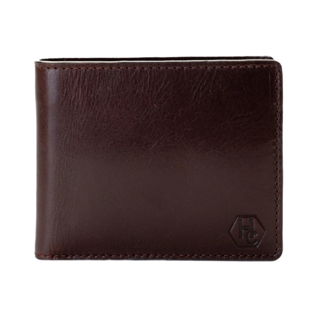 A dark brown leather bifold wallet with a tonal embossed logo on the bottom right corner, shown against a plain white background.