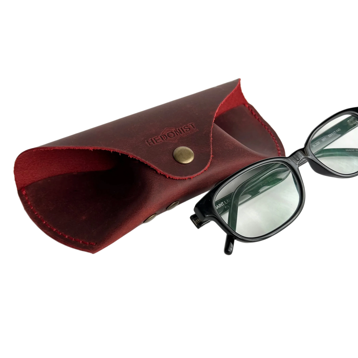 Soft Leather Eye Glasses Case in Red with black-framed eyeglasses resting beside it