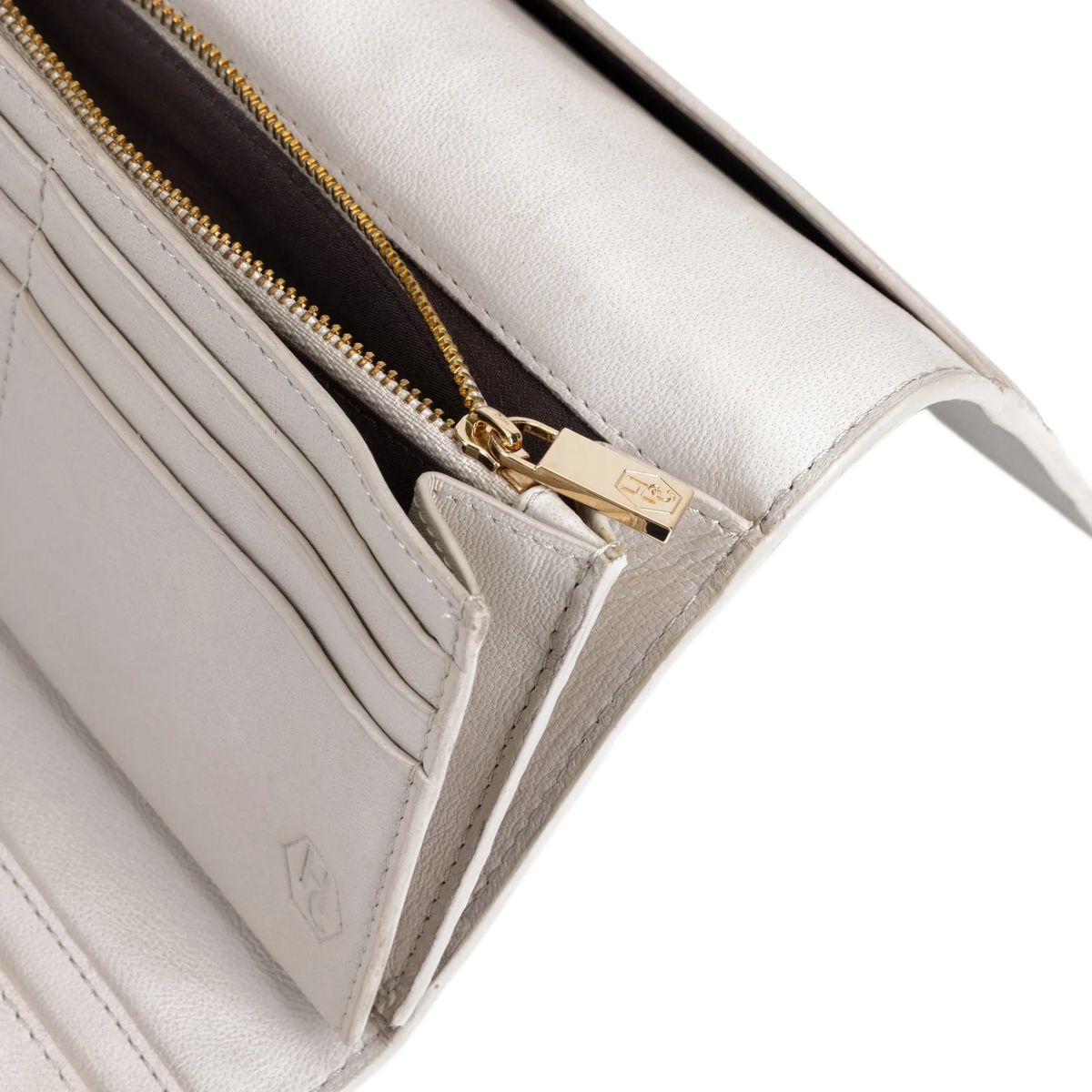 Close-up of gray leather trifold wallet showing card slots and gold zipper pull engraved with Hedonist Chicago