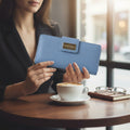 Person holding a blue wallet with a blurred background of a cafe setting