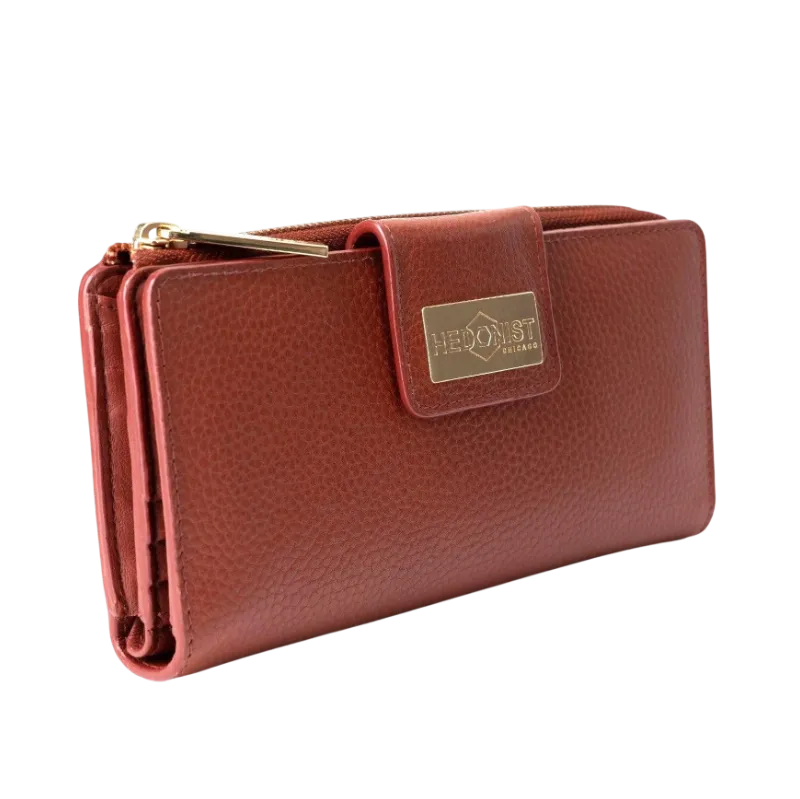 Large red pebbled leather travel wallet closed, front flap with gold-tone Hedonist Chicago plaque