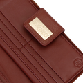 Snap-secured front flap detail on the large red pebbled leather travel wallet
