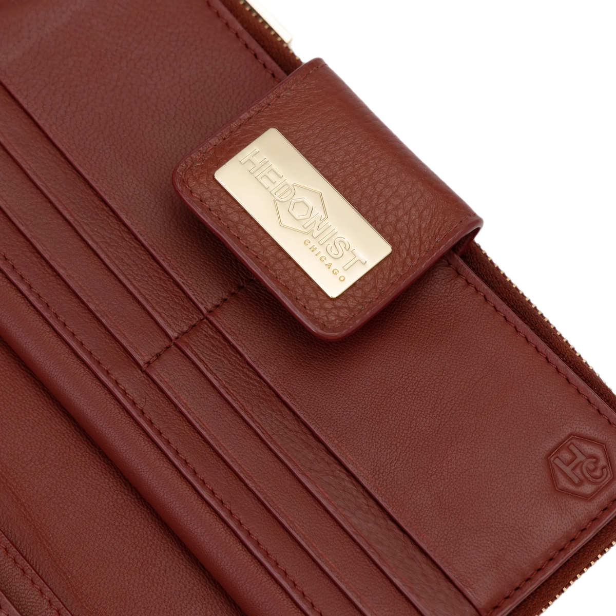 Snap-secured front flap detail on the large red pebbled leather travel wallet