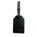Black full-grain leather luggage tag with brass buckle strap, embossed Hedonist Chicago logo on the front, shown on an off-white background.
