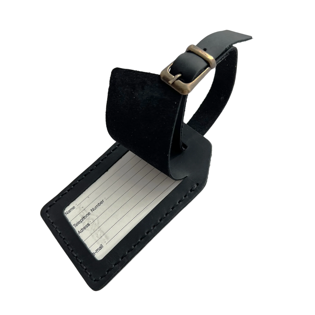 Black full-grain leather luggage tag with matching leather strap and brass buckle, shown on a light gray background.