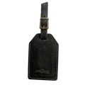 Black washed full-grain leather luggage tag with brass buckle strap, embossed Hedonist Chicago logo near the bottom, shown on a light background.