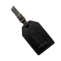 Black washed full-grain leather luggage tag with brass buckle, embossed Hedonist Chicago logo in the lower right corner, shown on a light gray background.