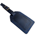 Navy blue full-grain leather luggage tag with blue contrast stitching and brass buckle strap, embossed Hedonist Chicago logo on the front, shown on an off-white background.