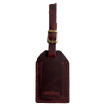 Burgundy full-grain leather luggage tag with brass buckle, embossed Hedonist Chicago logo near the bottom, shown on a white background.