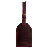 Burgundy full-grain leather luggage tag with brass buckle, embossed Hedonist Chicago logo near the bottom, shown on a white background.