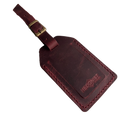 Burgundy full-grain leather luggage tag with matching leather strap and brass buckle, embossed Hedonist Chicago logo in the lower right corner, shown on a light gray background.