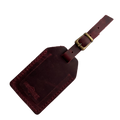 Burgundy full-grain leather luggage tag with brass buckle and strap, embossed Hedonist Chicago logo on the front, shown on a light background.