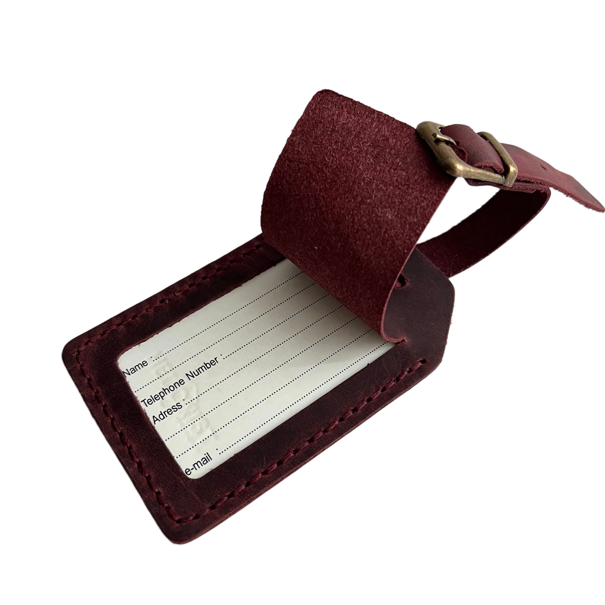 Burgundy full-grain leather luggage tag with matching adjustable strap and brass buckle, shown open on a light gray background.