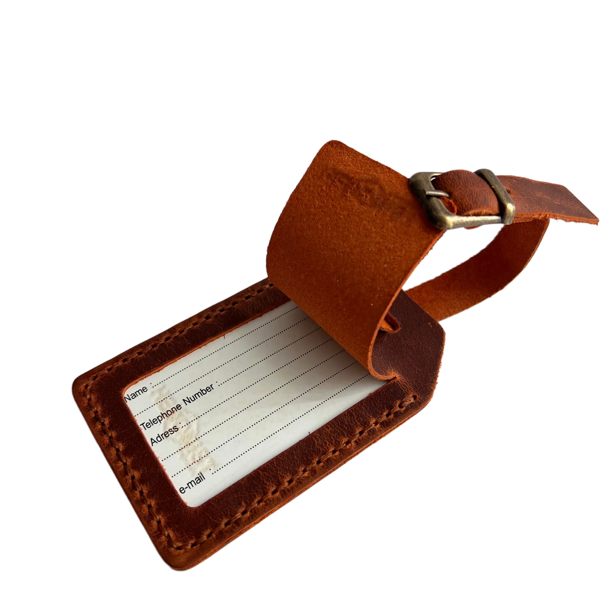 Cognac full-grain leather luggage tag with strap and brass buckle, shown with a printable ID insert card for name, phone, address, and email.