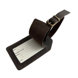 Dark brown full-grain leather luggage tag with matching adjustable strap and brass buckle, shown on a white background.