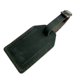Green full-grain leather luggage tag with matching leather strap and brass buckle, embossed Hedonist Chicago logo on the front, shown on a light gray background.