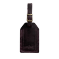 Plum full-grain leather luggage tag with brass buckle, embossed Hedonist Chicago logo on the front, shown on a light gray background.