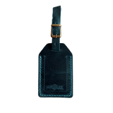 Teal full-grain leather luggage tag with matching leather strap and brass buckle, teal stitching, embossed Hedonist Chicago logo near the bottom, shown on a white background.