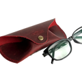 Soft Leather Eye Glasses Case in Red with black-framed eyeglasses resting beside it