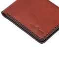 Handmade red brick leather bifold wallet, styled angled view