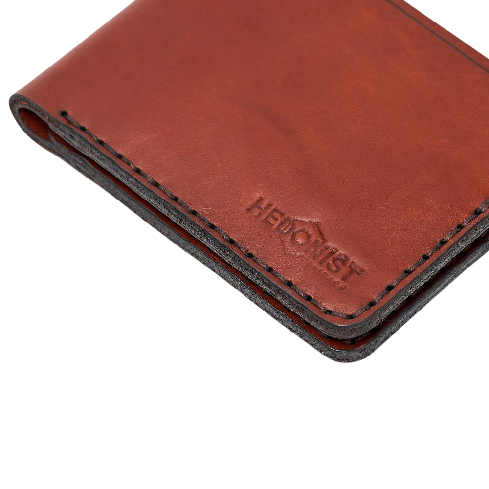 Handmade red brick leather bifold wallet, styled angled view