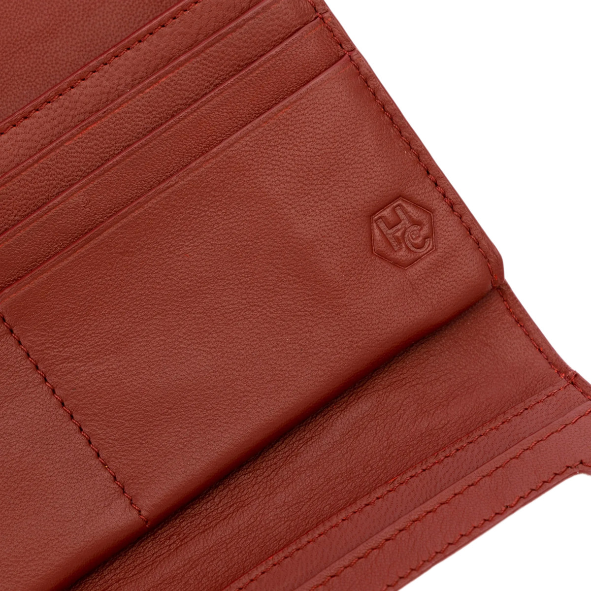 Close-up of red pebbled leather trifold wallet interior showing card slots and stitching detail